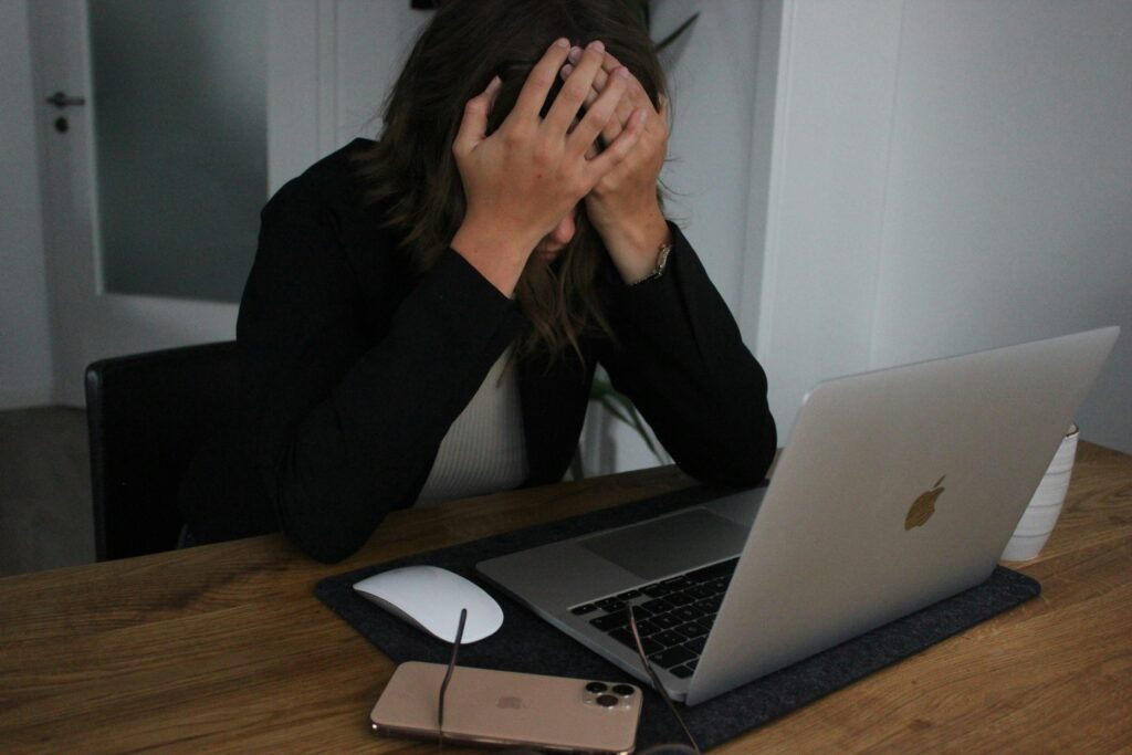 A frustrated man using a laptop, facing a missed deadline to appeal a denied Social Security benefits claim.