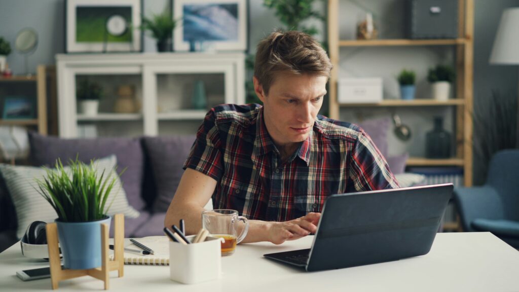 Man using a laptop to research long-term disability benefits and how a lawyer can help with claims, denials, and appeals.