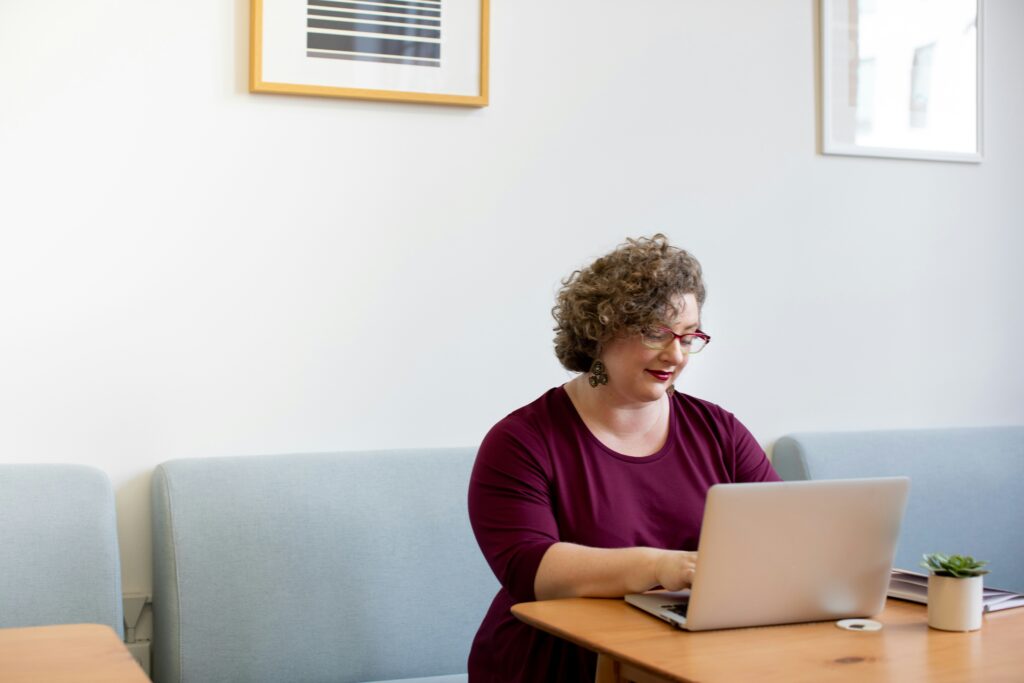 A woman using a laptop, exploring options and considerations for going back to work after receiving SSDI benefits.