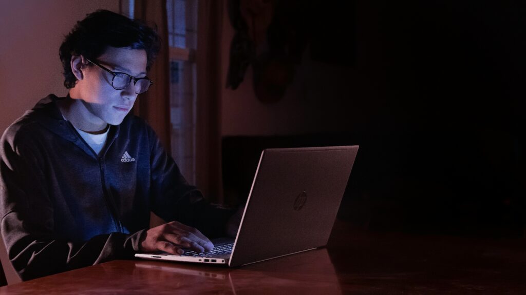 A man using a laptop, researching proposed SSDI cuts that were back on the table in 2016.