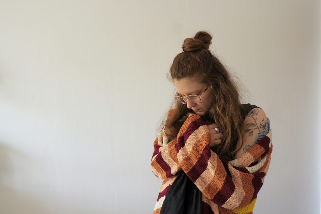 A woman holding her hand to her chest, representing the importance of accommodating employees with psychiatric disabilities in the workplace.