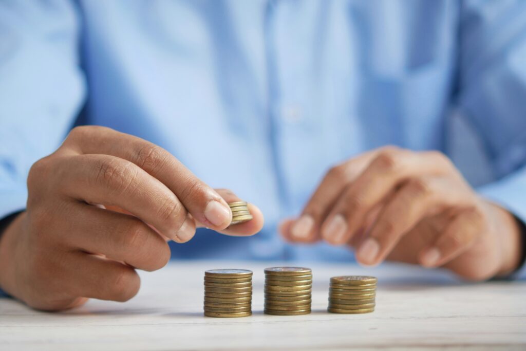 A man stacking coins, symbolizing the assessment and future planning of Social Security and Medicare benefits.