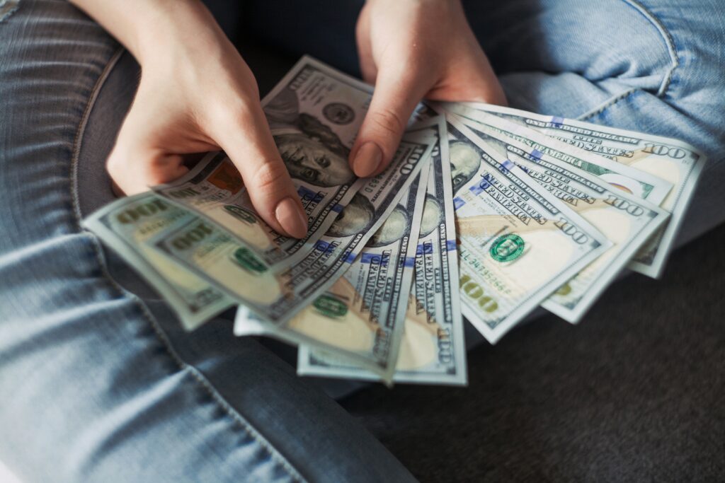 A person counting cash, representing SSI benefits for individuals with autism.
