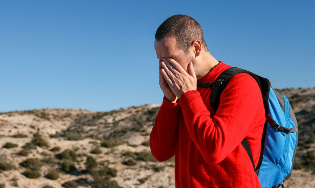 A man covering his face with his hands, illustrating frustration when an ALJ doesn’t properly weigh medical evidence for a claimant with bipolar disorder.