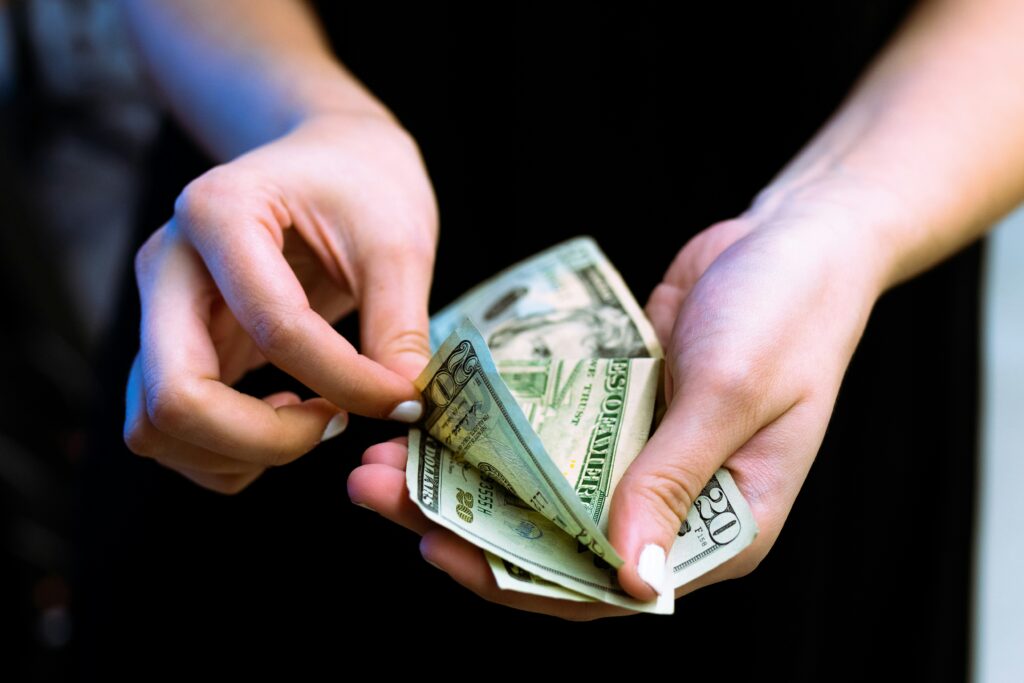 A person holding cash while learning about the SSA overpayment recovery rule change and its impact on SSDI and SSI recipients in California.