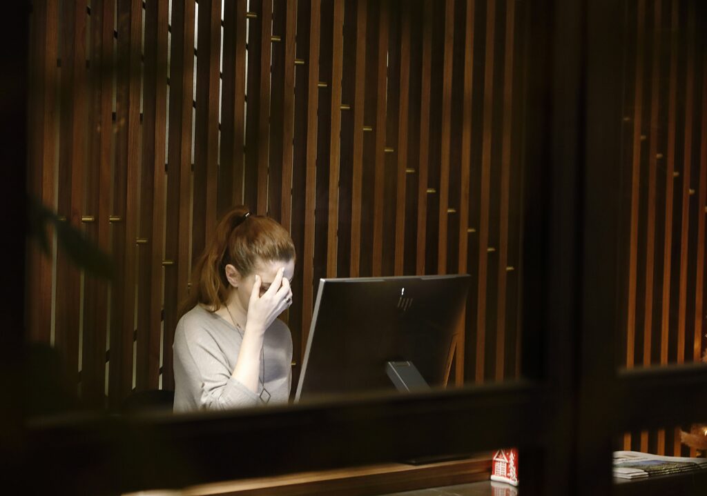 A frustrated woman using a computer, reflecting the challenges faced by SSDI and SSI claimants due to SSA office closures and staffing cuts.